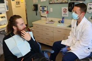 Dentist talking with patient in chair